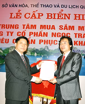 Đồng chí Hà Quang Long, Giám đốc Sở Văn hóa, Thể thao và Du lịch trao Quyết định cấp biển hiệu đạt tiêu chuẩn phục vụ khách du lịch cho ông Lê Nam Trung, Chủ tịch HĐQT Công ty CP Ngọc trai Hạ Long.
