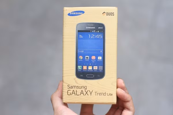Vỏ hộp Galaxy Trend Lite vẫn giữ kiểu dáng vân gỗ đặc trưng của Samsung với hình ảnh sản phẩm, logo Samsung và biểu tượng Duos đặc biệt đánh dấu đặc điểm 2 sim 2 sóng.