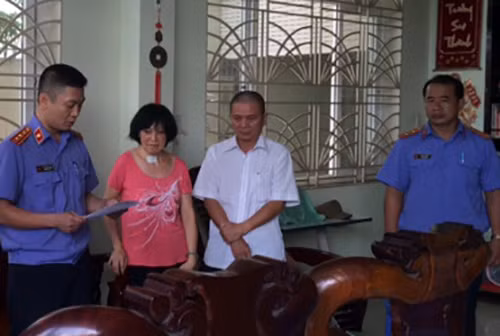 Ông Châu Tùng Chinh nghe đọc lệnh khám xét nhà. Ảnh: Cửu Long
