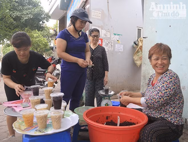  Rượu nếp là món được mọi người chọn mua nhiều nhất, bởi quan niệm ăn rượu nếp lúc đang đói sẽ làm sâu bọ trong người say mà chết đi. Bà Lan đang cười vui mừng khi nhiều người tìm đến hàng rượu nếp cẩm của mình, bà cho biết nhiều người mua rượu từ lúc 5h30 để mang về... 
