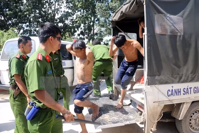 Lực lượng chức năng đưa học viên bỏ trốn về trại tập trung. (Ảnh: Đoàn Mạnh Dương/TTXVN)