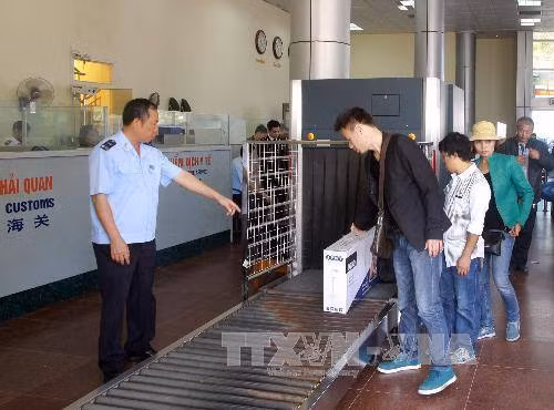 Nhân viên hải quan giám sát hành lý của khách nhập cảnh qua cửa khẩu Móng Cái. Ảnh: Hoàng Hùng/TTXVN