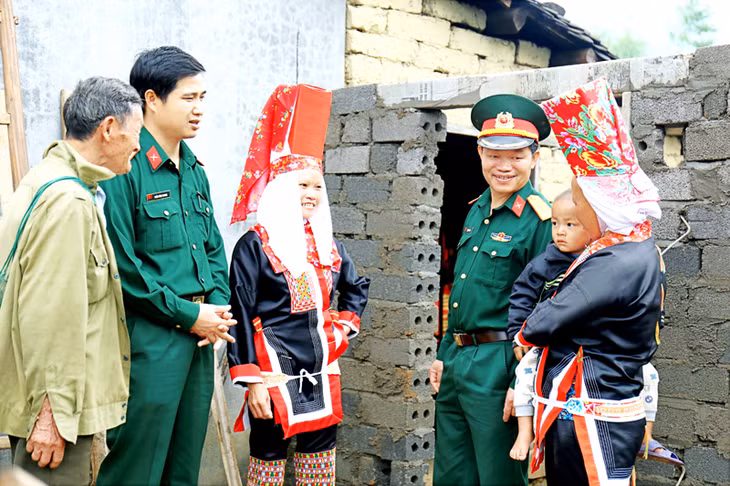 Cán bộ, chiến sĩ Ban CHQS huyện Bình Liêu thăm hỏi, tuyên truyền chính sách pháp luật, bảo vệ an ninh biên giới cho bà con dân tộc xã Đồng Văn. 