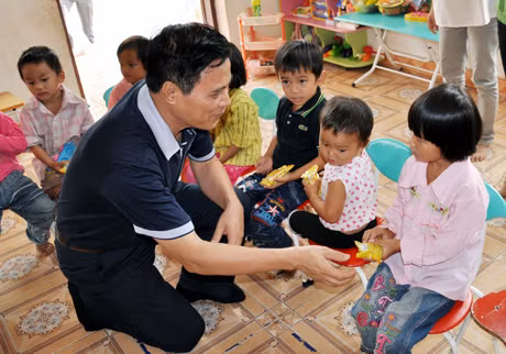 Đồng chí Nguyễn Tiến Mạnh, Tổng Biên tập Báo Quảng Ninh phát bánh kẹo cho học sinh điểm trường Khe Tre, Trường Mầm non Kỳ Thượng, huyện Hoành Bồ.