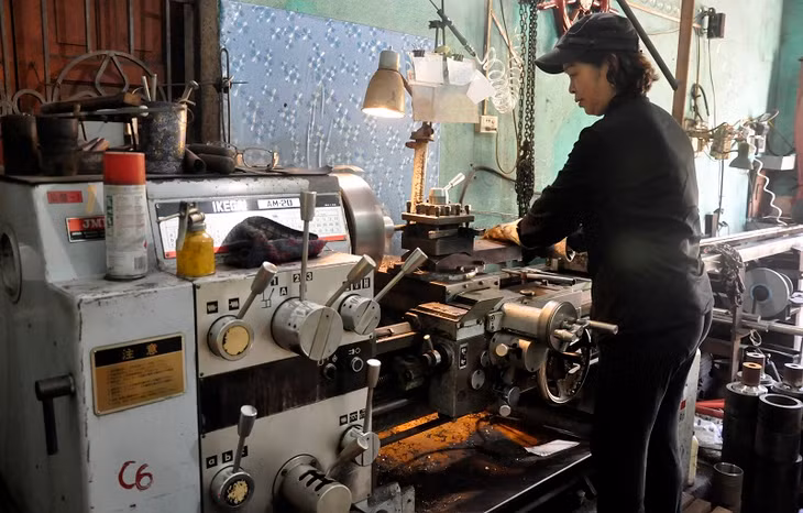 Bà Loan đứng máy tiện trục chân vịt.