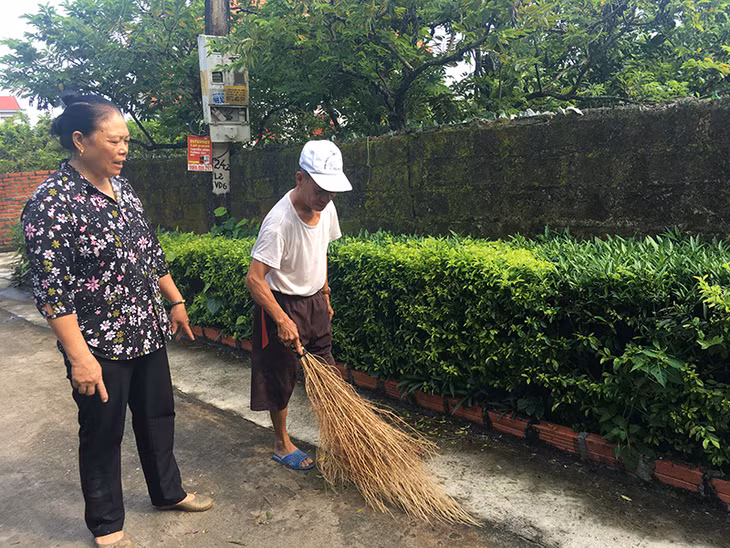 Bà Nguyễn Thị Minh Tư vận động hộ dân vệ sinh đường xóm.