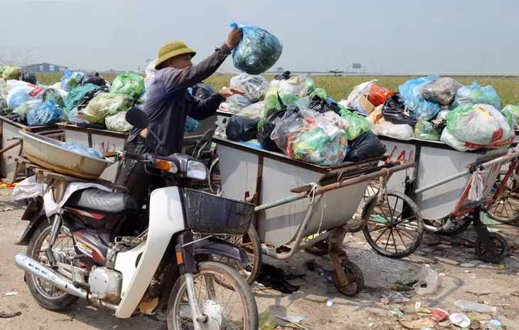 Ông Nguyễn Bá Tành, khu dân cư 14 (phường Hà An) đem rác của gia đình ra điểm tập kết rác của phường tại khu dân cư 11.