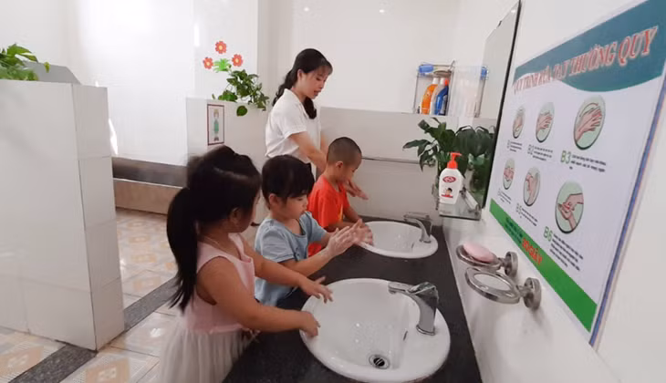 Cô giáo hướng dẫn các trẻ trường mầm non Hà Khẩu (TP Hạ Long) rửa tay bằng xà phòng đúng cách.