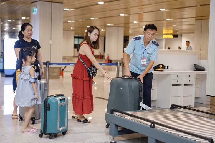 Cán bộ hải quan Chi cục Hải quan cửa khẩu cảng Cẩm Phả hỗ trợ hành khách trong quá trình làm thủ tục xuất nhập cảnh tại Cảng hàng không Quốc tế Vân Đồn.