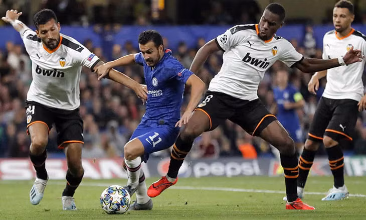 Pedro giữa vòng vây của các hậu vệ cao to phía Valencia. Ảnh: AP.