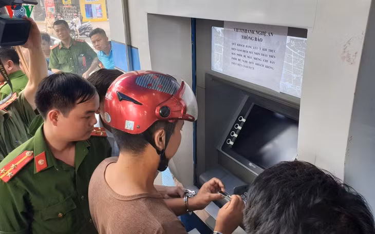 Một trong số các nghi phạm thực nghiệm lại hành vi cài thiết bị điện tử vào cột ATM.