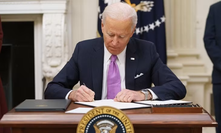 Tổng thống Mỹ Joe Biden ký sắc lệnh Covid-19 tại Nhà Trắng hôm 21/1. Ảnh: AFP.