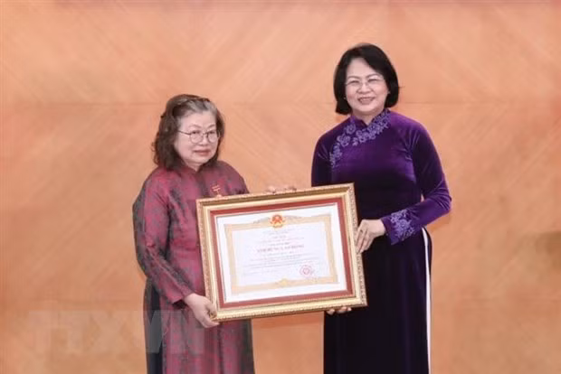 Thừa ủy quyền của Chủ tịch nước, Phó Chủ tịch nước Đặng Thị Ngọc Thịnh trao danh hiệu Anh hùng Lao động thời kỳ đổi mới của Thầy thuốc Nhân dân, Giáo sư, Tiến sỹ Huỳnh Thị Phương Liên. (Ảnh: Minh Quyết/TTXVN)