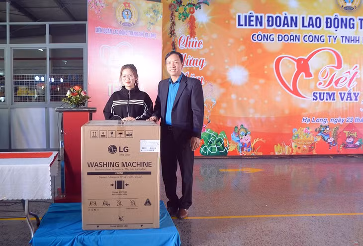 Ông Phạm Ngọc Hưng, Chủ tịch LĐLĐ TP Hạ Long trao chiếc phần quà giá trị là chiêc máy giặt cho công nhân may mắn trúng thưởng.