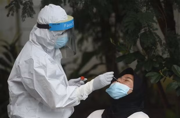 Nhân viên y tế lấy mẫu xét nghiệm COVID-19 tại Jakarta, Indonesia. (Ảnh: THX/TTXVN)