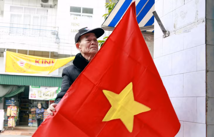 Người Đảng viên lão thành ở khu Quang Trung (thị trấn Tiên Yên) nâng niu lá cờ Tổ quốc để treo trước cửa nhà.