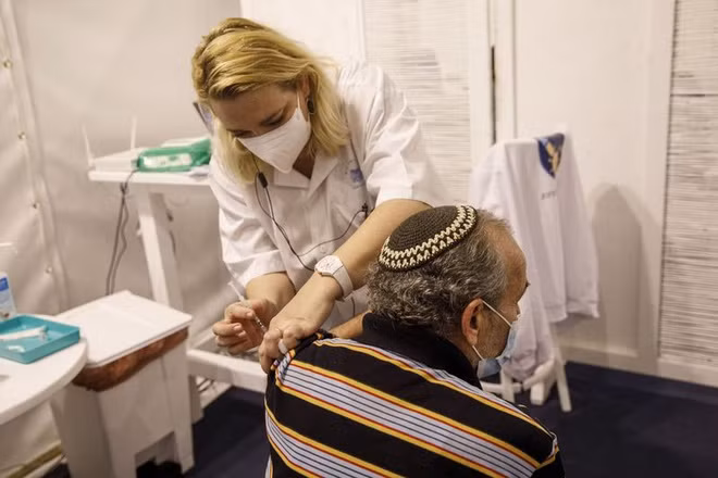 Một y tá tiêm vaccine Covid-19 cho người dân tại một trung tâm tiêm chủng hàng loạt ở Tel Aviv vào ngày 4/1. Ảnh: Bloomberg.