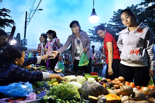 Công nhân Khu công nghiệp Tân Tạo, quận Bình Tân mua đồ ăn sau khi tan ca. Ảnh: Hữu Khoa.
