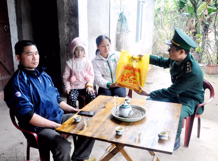 Cán bộ Đồn Biên phòng cửa khẩu Hoành Mô tặng quà Tết cho hộ chị Dương Thị Vòng (bản Nà Dun, xã Hoành Mô, huyện Bình Liêu).