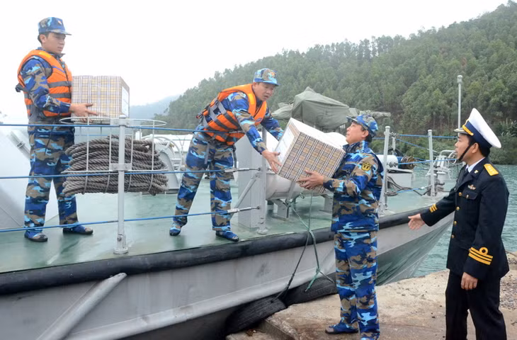 Những thùng quà đang được các cán bộ chiến sỹ của tàu 285 thuộc Lữ đoàn 170 truyền tay nhau đưa xuống đảo