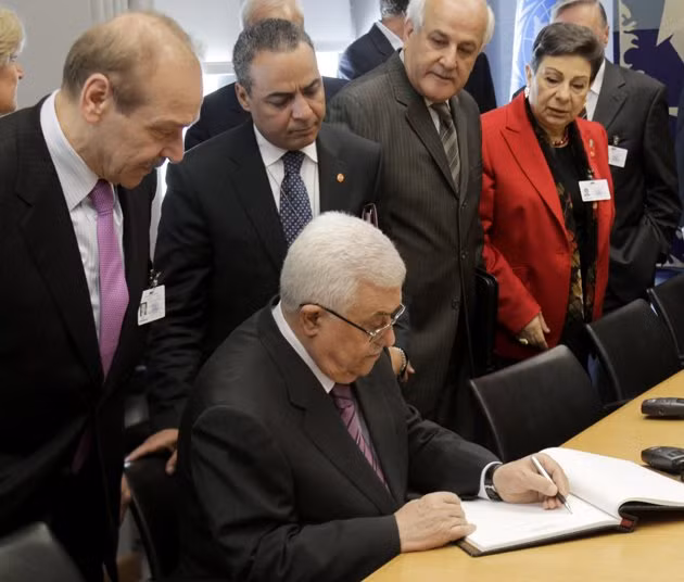 Tổng thống Palestinian Mahmoud Abbas ký vào một cuốn sách trước khi có cuộc gặp với Tổng thư ký LHQ Ban Ki-moon hôm 19.9. Ảnh: AP