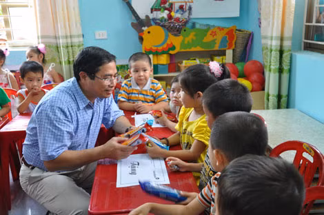 Đồng chí Phạm Minh Chính, Ủy viên T.Ư Đảng, Bí thư Tỉnh ủy trao quà cho các cháu Trường Mầm non xã Xuân Sơn.