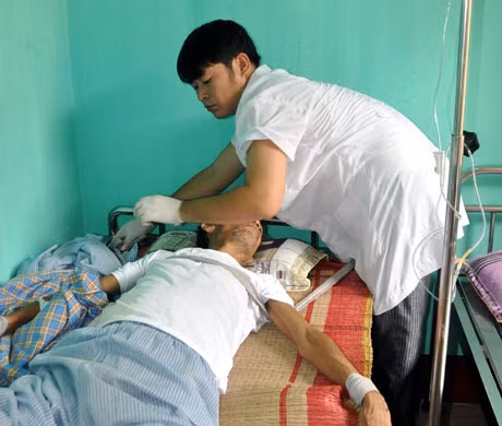 Điều dưỡng viên Lê Văn Khắc đang chăm sóc cho bệnh nhân Nguyễn Văn C bị loạn thần vì rượu.