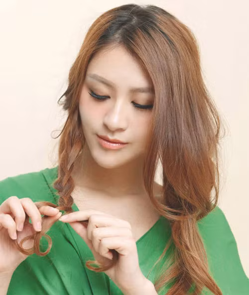 Đầu tiên bạn lấy một lọn tóc ở bên phải, sát tai để tết lọn lại.