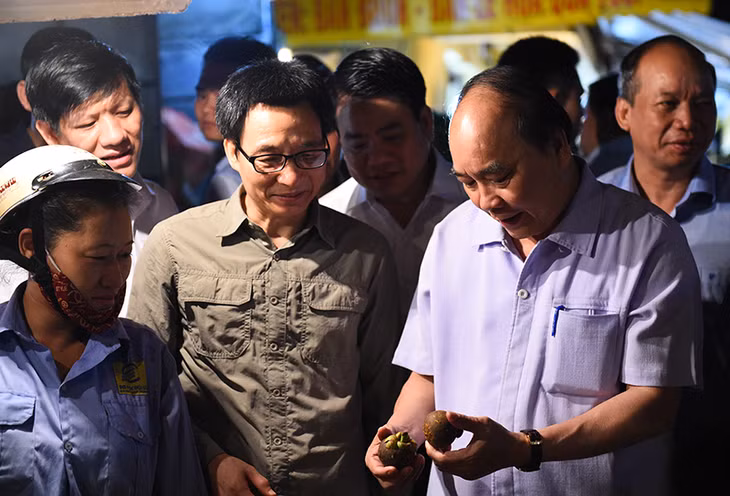 Thủ tướng Nguyễn Xuân Phúc, Phó Thủ tướng Vũ Đức Đam thị sát chợ đầu mối Long Biên, TP Hà Nội, sáng sớm 27/9. Ảnh: VGP/Quang Hiếu