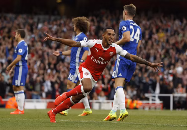 Biểu cảm vui mừng của Walcott sau khi ghi bàn thứ hai trái ngược với nỗi thất vọng của các cầu thủ Chelsea. Ảnh: Reuters.