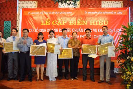 Đại diện lãnh đạo Sở VHTT&DL và Hiệp hội Du lịch Quảng Ninh trao biển hiệu cho các cơ sở kinh doanh đạt tiêu chuẩn phục vụ khách du lịch.