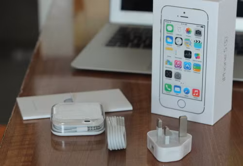  Hộp máy thiết kế theo phong cách iOS 7, hình minh họa phẳng. Bộ phụ kiện đi kèm như với iPhone 5, nhưng thiếu bộ chuyển micro USB sang lightning như ở iPhone 5C.