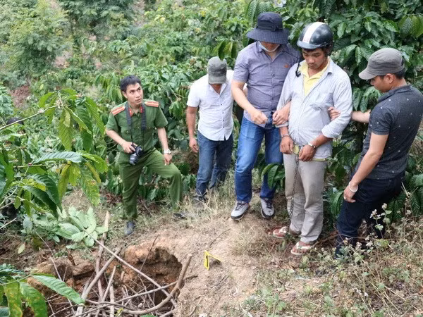 Nghi phạm Trần Quốc Vũ được đưa tới địa điểm phi tang thi thể nạn nhân để thực nghiệm hiện trường vụ án. (Ảnh: Nguyễn Dũng/TTXVN)