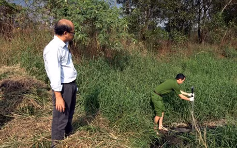 Cán bộ Cảnh sát Môi trường Công an Tây Ninh lấy mẫu nước thải giám định. (Ảnh: Báo Công an TPHCM)