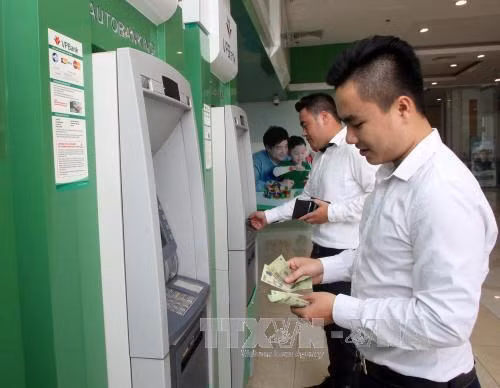 Rút tiền tại cây ATM. Ảnh: TTXVN