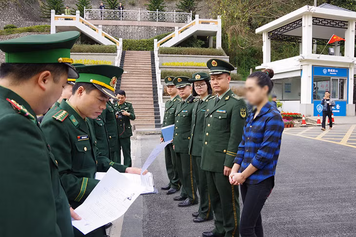 Cơ quan chức năng Quảng Tây và BĐBP Quảng Ninh làm thủ tục trao trả - tiếp nhận đối tượng vượt biên trái phép. (Ảnh do đơn vị cung cấp)