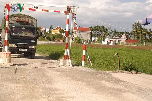 Người dân dựng barie chắn ngang ngăn xe quá tải đi vào đường làng.