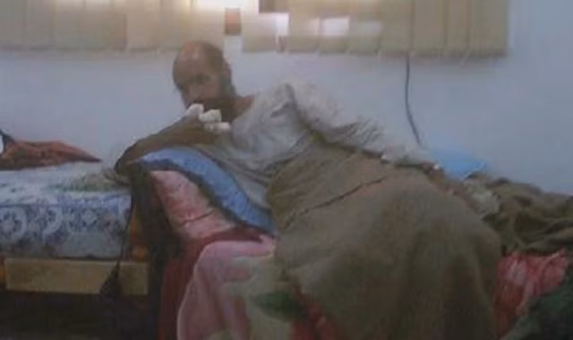 Saif al-Islam Gaddafi với hình ảnh bàn tay bị băng bó trên truyền hình.