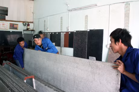 Cơ sở sản xuất đá ốp lát của anh Cao Văn Duyệt, một người lầm lỗi tiến bộ (đứng giữa) ở phường Cẩm Phú (Cẩm Phả).