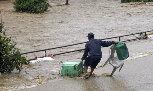 Người đàn ông cố gắng di chuyển trong nước lũ tại Kalanki, Nepal ngày 12/7. Ảnh: AFP.