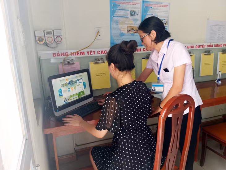 Công chức bộ phận tiếp nhận và trả kết quả hiện đại phường Cẩm Phú (TP Cẩm Phả) hướng dẫn người dân tra cứu thông tin liên quan đến thủ tục hành chính
