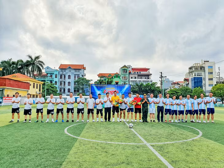 Lãnh đạo hai đơn vị tặng hoa, chụp ảnh lưu niệm cùng cầu thủ.