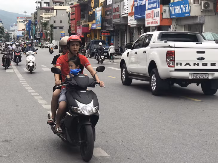Nhiều người còn cho trẻ em ngồi đăng trước bám vào tay lái xe mô tô cũng rất nguy hiểm 
