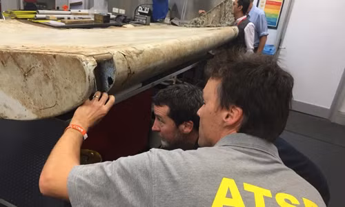 Các nhân viên Cục An toàn Giao thông Australia xem xét mảnh vỡ được cho là của MH370. Ảnh: AP.