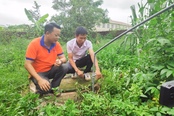 Cán bộ xã Quảng Lợi, huyện Đầm Hà (bên trái) kiểm tra chất lượng bể biogas của hộ anh Trần Văn Hiếu, người dân ở thôn Trung Sơn của xã.