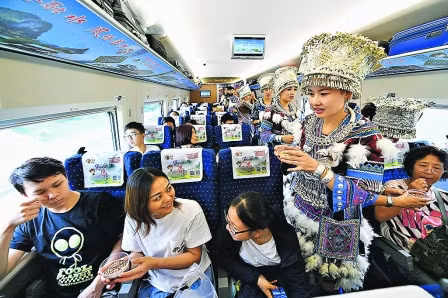 Nhân viên ngành đường sắt trong trang phục dân tộc chào đón những vị khách đầu tiên của tuyến đường sắt cao tốc Nam Ninh - Hồng K ông. 