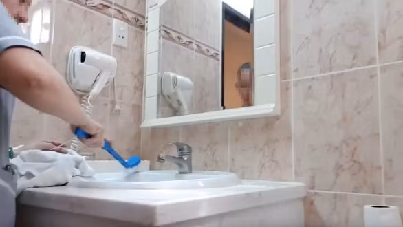  Nhân viên khách sạn T.T. ở Q.1, TP.HCM dùng chổi chà bồn cầu, sau đó chà bồn rửa mặt và bồn tắm