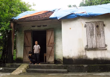 Ngôi nhà của vợ chồng anh Trung đã xuống cấp nghiêm trọng, phải dùng bạt che mái ngói tránh mưa dột.