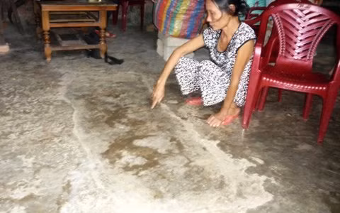 Bà T. chỉ tay lên dấu vết cái huyệt giữa nhà mà trước đây chồng đào đòi chôn sống mình.