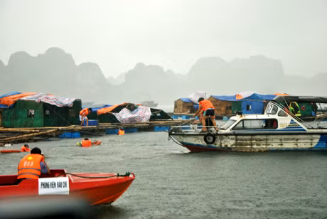 Tiếp cận các nhà bè nuôi trồng thuỷ sản trên biển để cứu người bị nạn trong mưa bão.